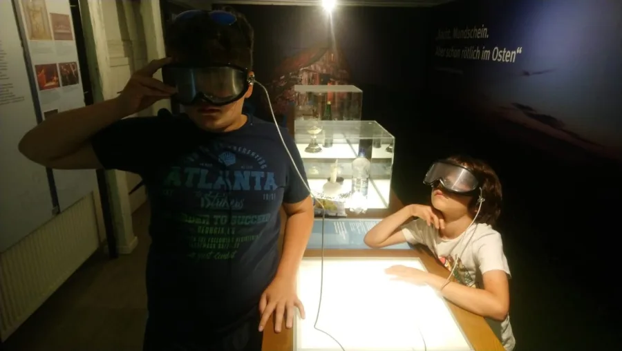 Museumsbesuch. Zwei Kinder mit Schutzbrille